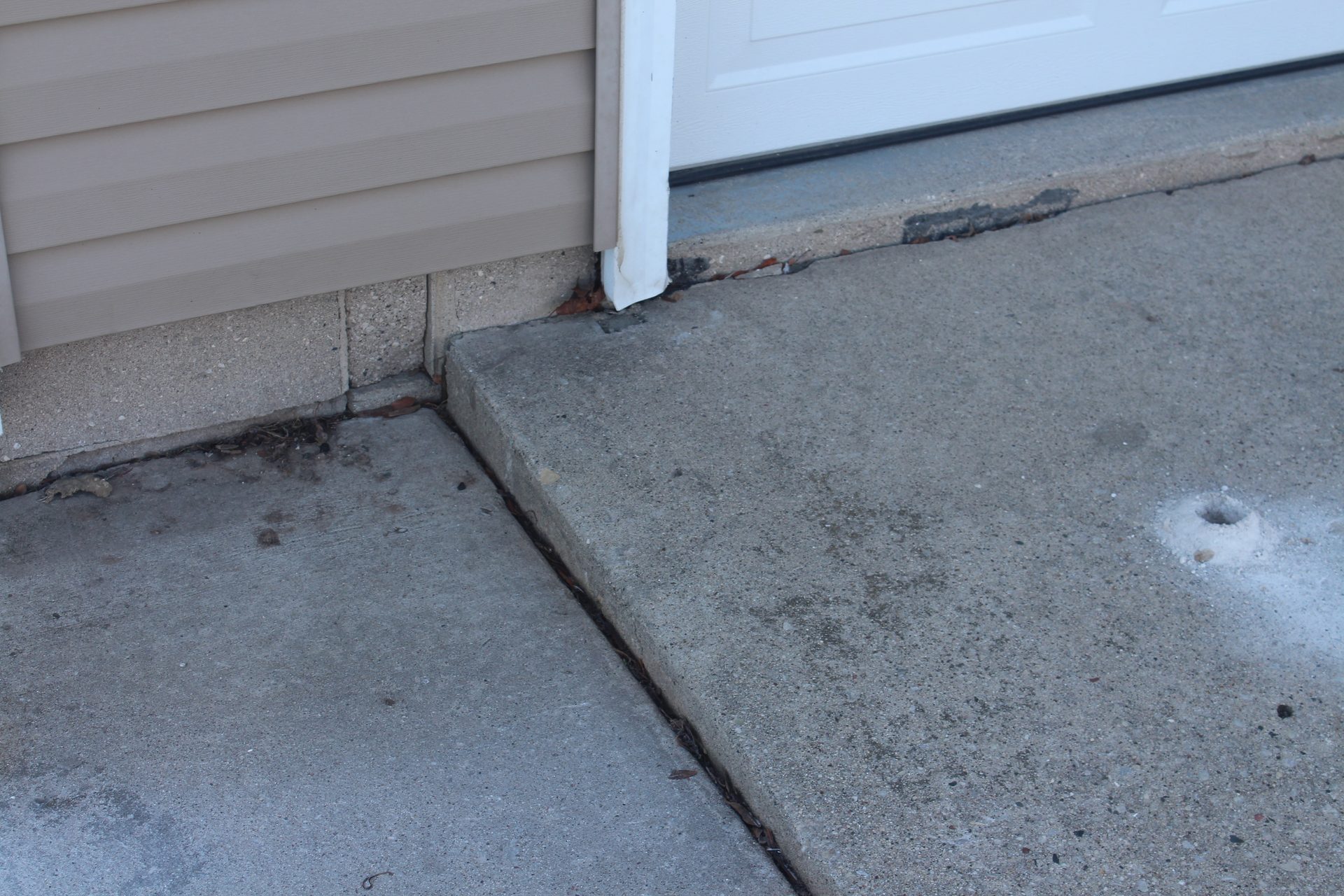 Settled backyard patio with dropped slab before foam lifting repair